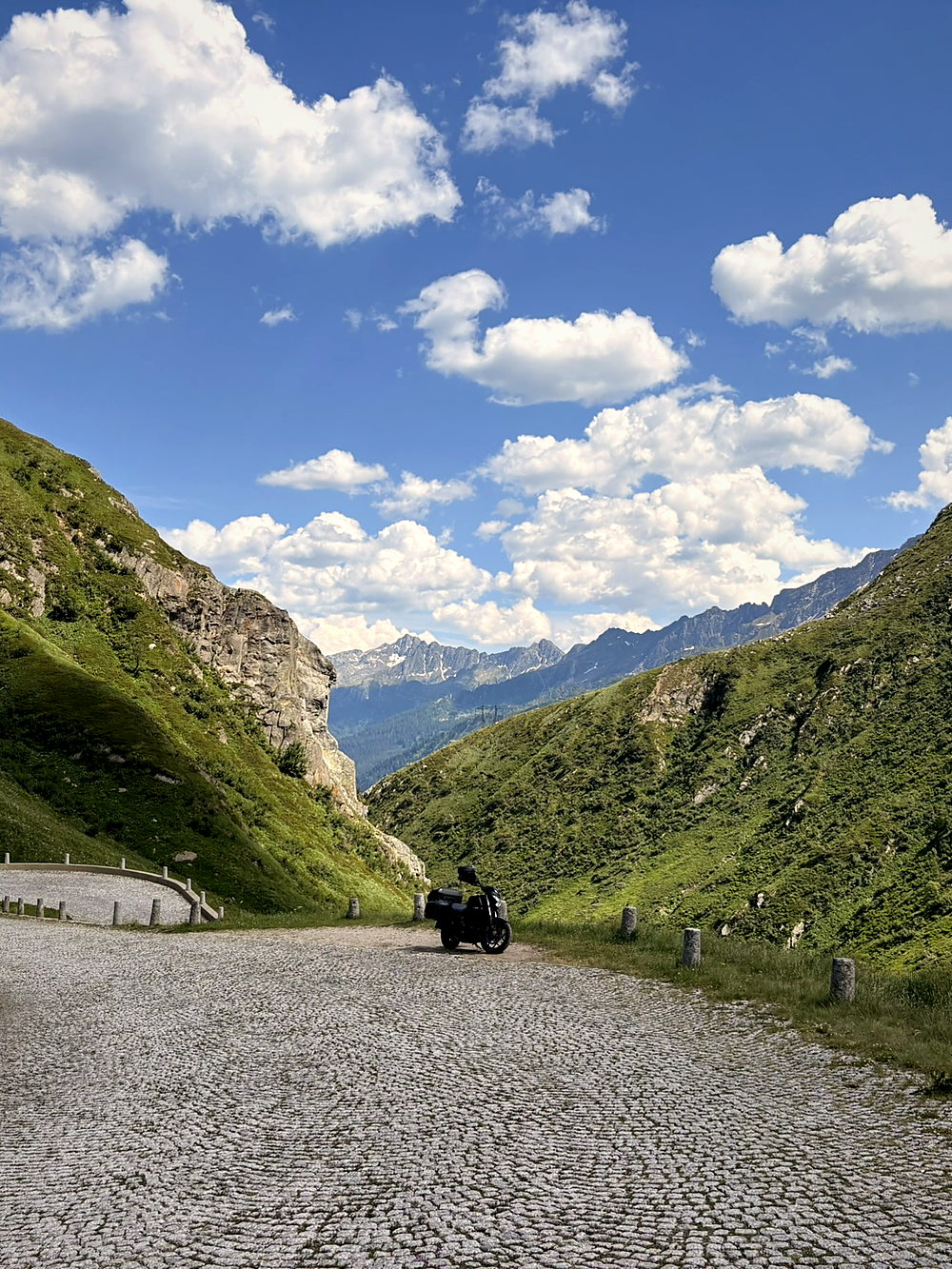 The cobbled Tremola road on the Gotthard Pass with a motorcycle parked at the far end