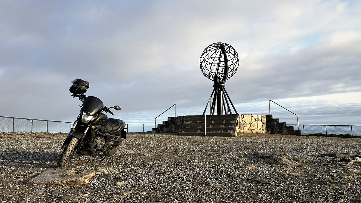 A motorcycle beside the globe monument at Nordkapp, the northern edge of Europe